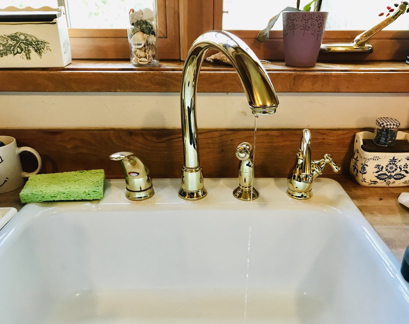 Illustrative photo: brass faucet over a farmhouse sink